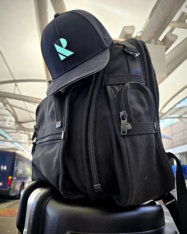 black Ridgeback hat resting on a black backpack in an airport terminal