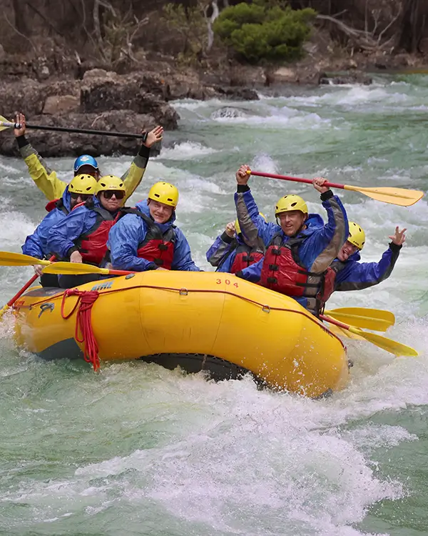 group rafting through whitewater rapids in a yellow raft