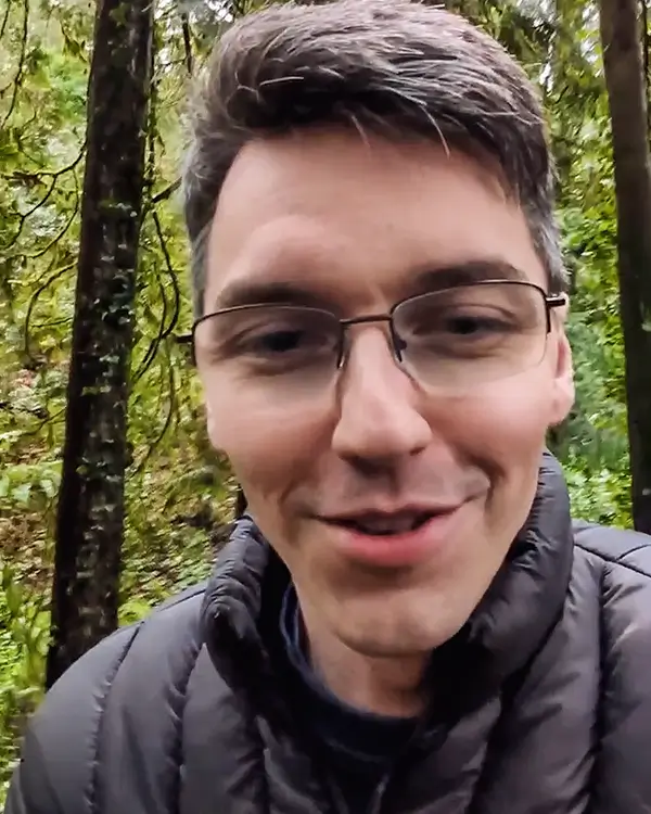 Brendan Costello speaking outdoors in a wooded area