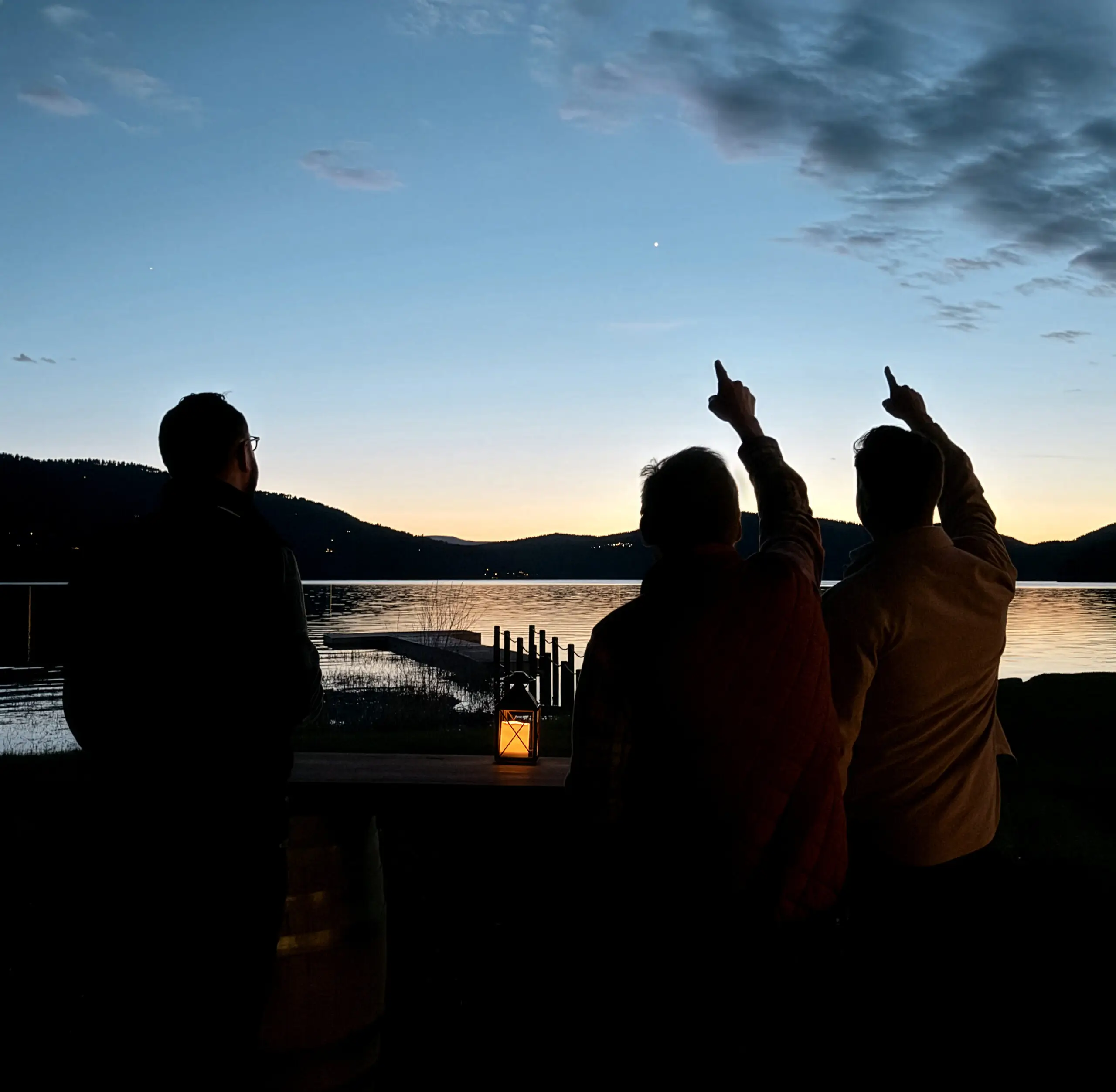 three people looking up at the night sky